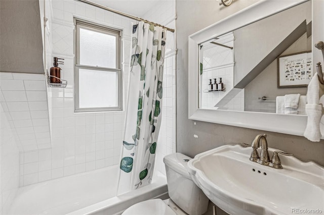bathroom featuring toilet, a sink, and shower / tub combo