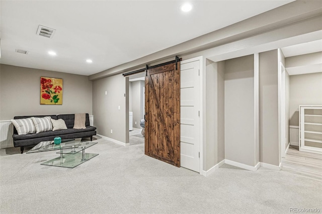 living room featuring light colored carpet, visible vents, a barn door, baseboards, and recessed lighting