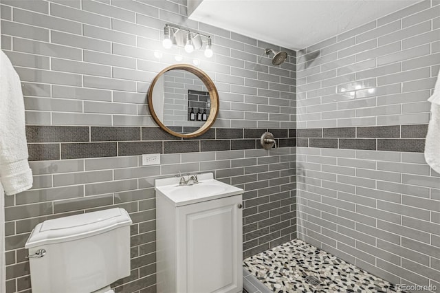 bathroom with vanity, toilet, and tiled shower