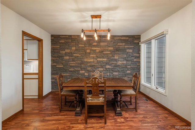 dining area featuring visible vents, baseboards, and wood finished floors