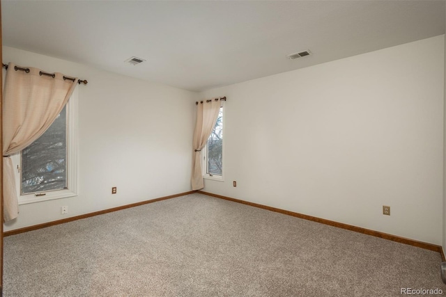 unfurnished room featuring visible vents, baseboards, and carpet floors