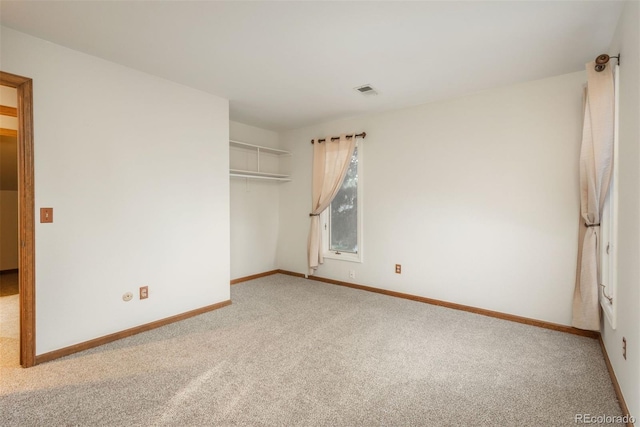 carpeted spare room featuring baseboards and visible vents