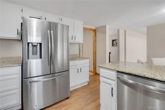 5603 S Pagosa Ct, Centennial, CO 80015 - kitchen with light wood-style flooring, appliances with stainless steel finishes, white cabinetry, and light stone countertops