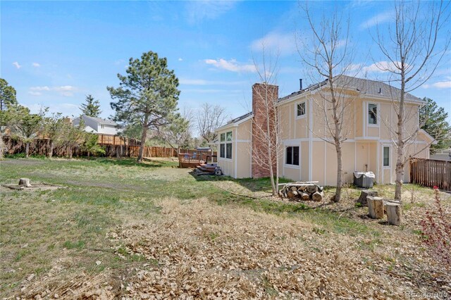 5603 S Pagosa Ct, Centennial, CO 80015 - view of side of property with a chimney, a lawn, a wooden deck, central air condition unit, and fence