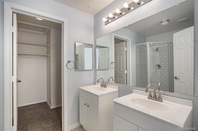 full bath featuring a shower stall, two vanities, and baseboards
