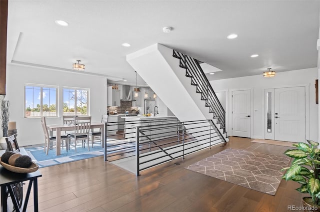 foyer entrance featuring stairs, light wood-style flooring, recessed lighting, and baseboards