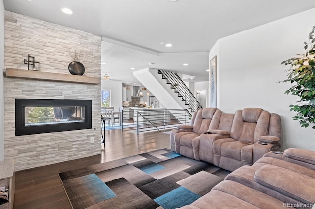 living room with recessed lighting, a fireplace, stairs, and wood finished floors