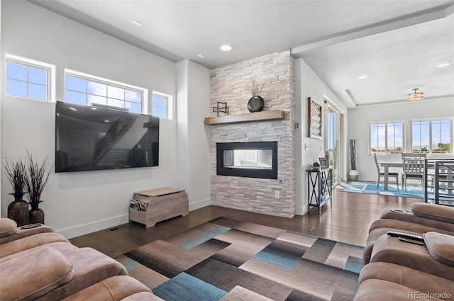 living area featuring recessed lighting, baseboards, wood finished floors, and a fireplace