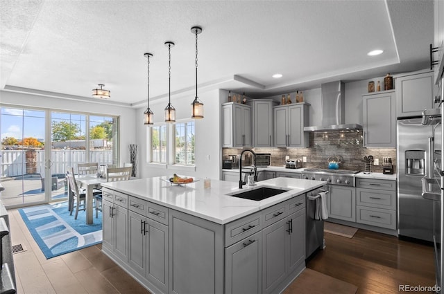 kitchen featuring wall chimney exhaust hood, gray cabinets, and appliances with stainless steel finishes