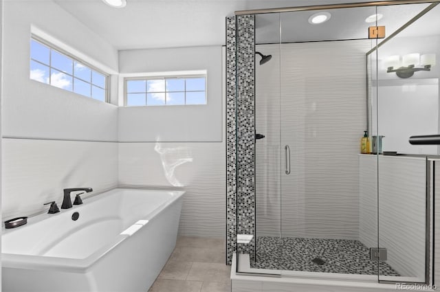 bathroom with a garden tub, tile patterned floors, and a shower stall