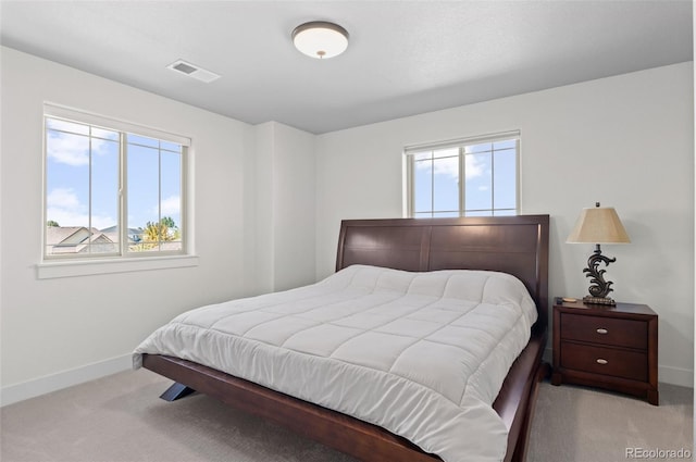 carpeted bedroom featuring visible vents, multiple windows, and baseboards