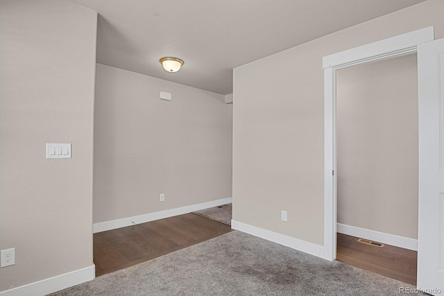 spare room with dark colored carpet