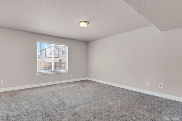 carpeted empty room with a textured ceiling