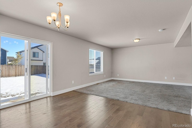 spare room with a chandelier and hardwood / wood-style flooring