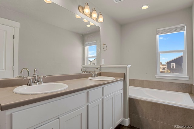 bathroom with vanity and a relaxing tiled tub