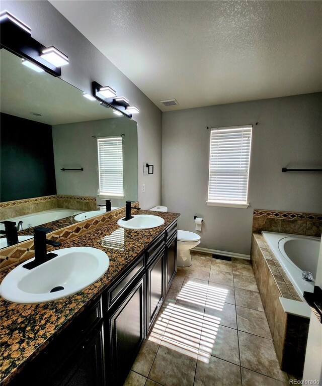 full bathroom featuring tile patterned flooring, a garden tub, and a sink