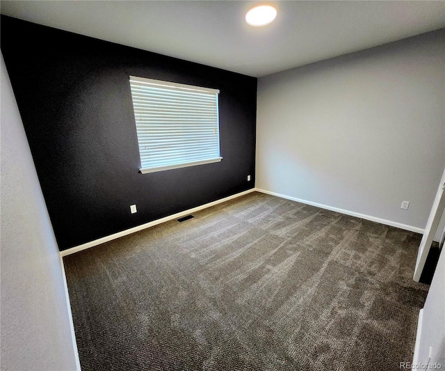 spare room with visible vents, baseboards, and carpet