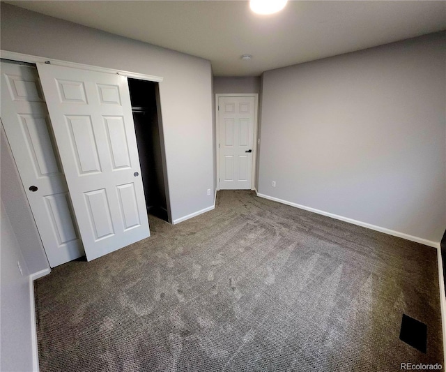 unfurnished bedroom featuring a closet, baseboards, and carpet flooring