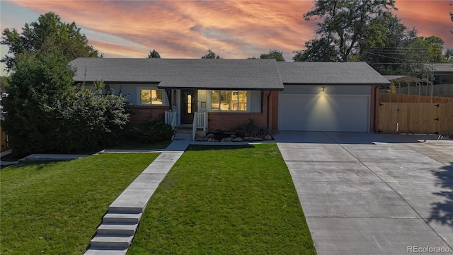 ranch-style home featuring a yard and a garage