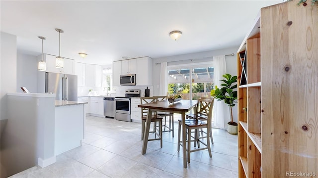 dining room featuring sink and light tile patterned flooring