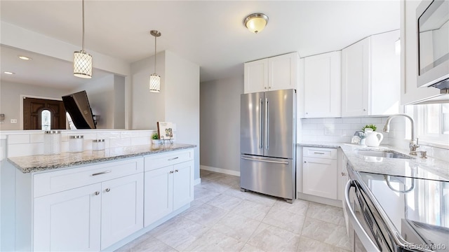 kitchen featuring white cabinetry, appliances with stainless steel finishes, sink, and hanging light fixtures