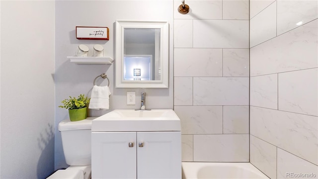 bathroom featuring vanity, a bath, and toilet