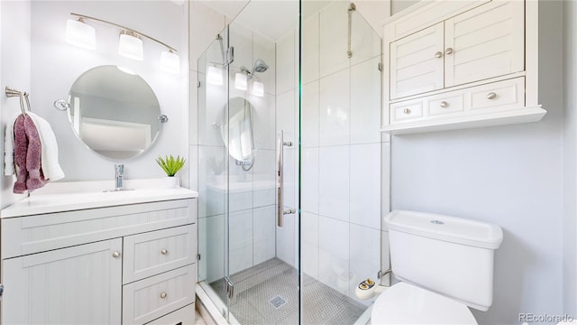 bathroom with toilet, a shower with shower door, and vanity