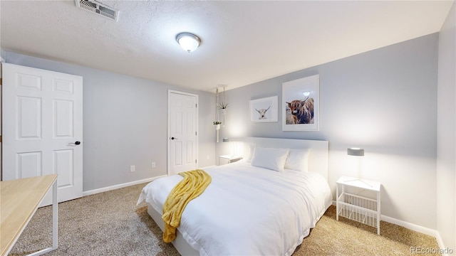 bedroom featuring a textured ceiling and carpet