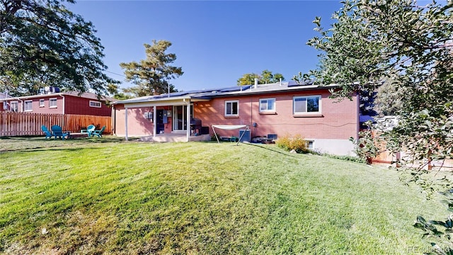 back of house featuring a patio area and a lawn