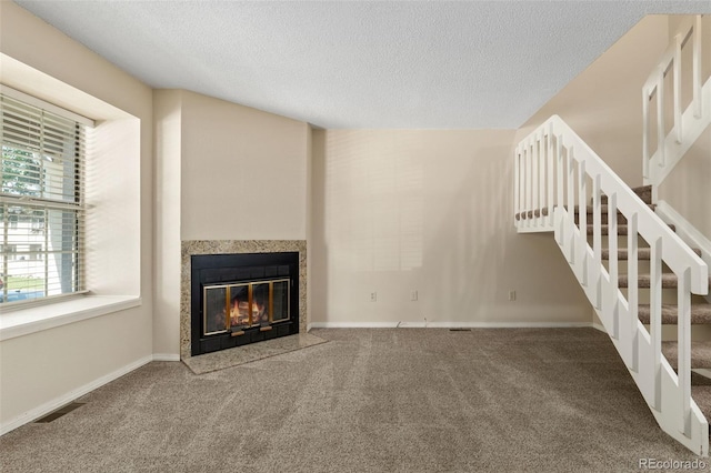 18171 E Arizona Ave Unit B, Aurora, CO 80017 - unfurnished living room with a tiled fireplace, stairway, carpet, a textured ceiling, and baseboards