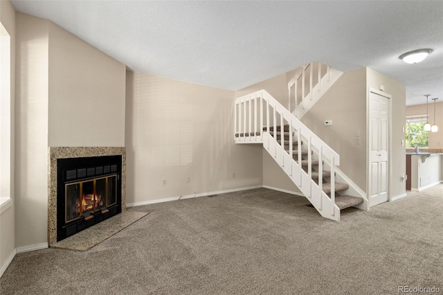 18171 E Arizona Ave Unit B, Aurora, CO 80017 - unfurnished living room featuring stairs, carpet, a textured ceiling, baseboards, and a premium fireplace