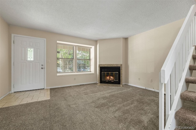 18171 E Arizona Ave Unit B, Aurora, CO 80017 - unfurnished living room featuring carpet floors, stairs, a textured ceiling, a fireplace with flush hearth, and baseboards