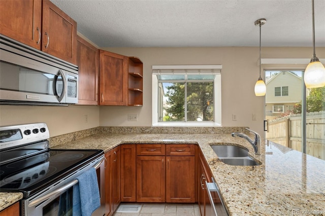 18171 E Arizona Ave Unit B, Aurora, CO 80017 - kitchen featuring appliances with stainless steel finishes, a sink, light stone counters, pendant lighting, and brown cabinetry