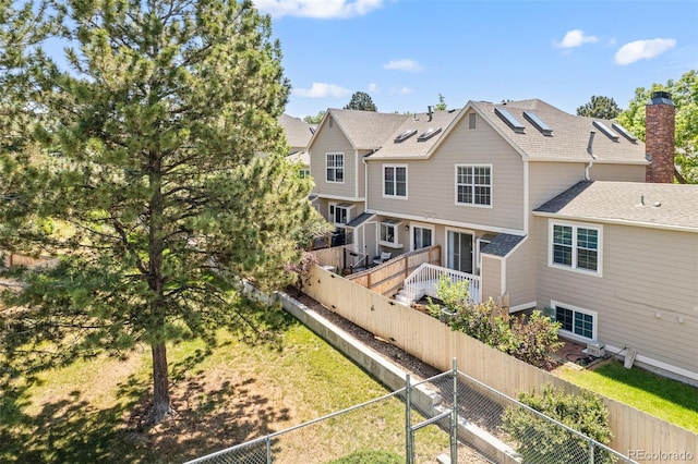 18171 E Arizona Ave Unit B, Aurora, CO 80017 - back of house with a fenced backyard, a chimney, and roof with shingles
