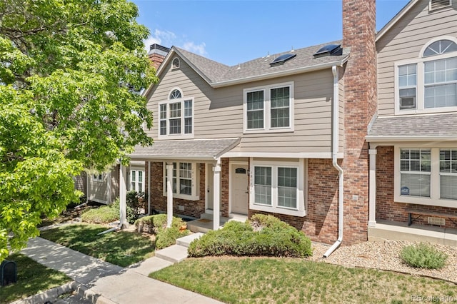 18171 E Arizona Ave Unit B, Aurora, CO 80017 - view of front of house with brick siding, a chimney, and a front yard