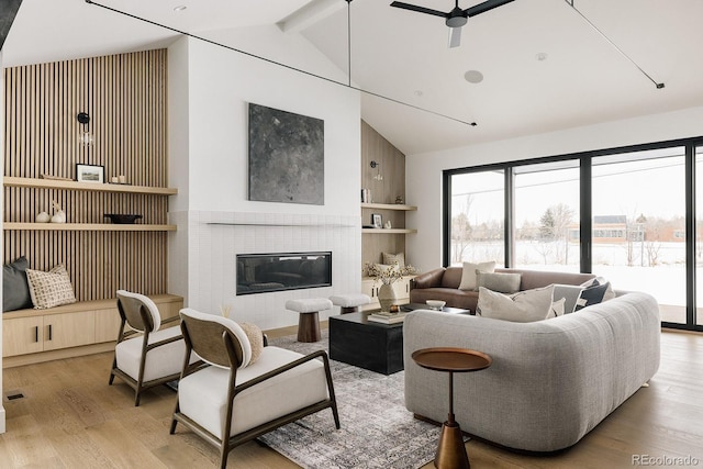 living room with lofted ceiling with beams, ceiling fan, and light hardwood / wood-style flooring