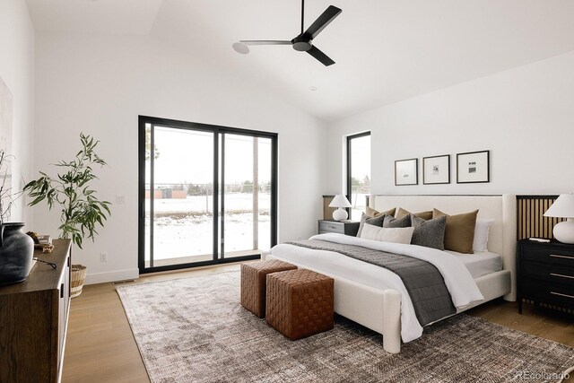 bedroom with hardwood / wood-style flooring, ceiling fan, access to exterior, and high vaulted ceiling