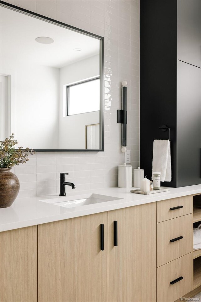 bathroom with vanity, decorative backsplash, and tile walls