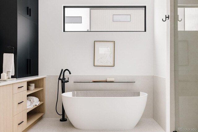 bathroom with vanity, a tub, and a healthy amount of sunlight