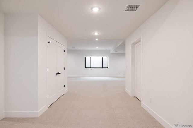 hallway with light colored carpet