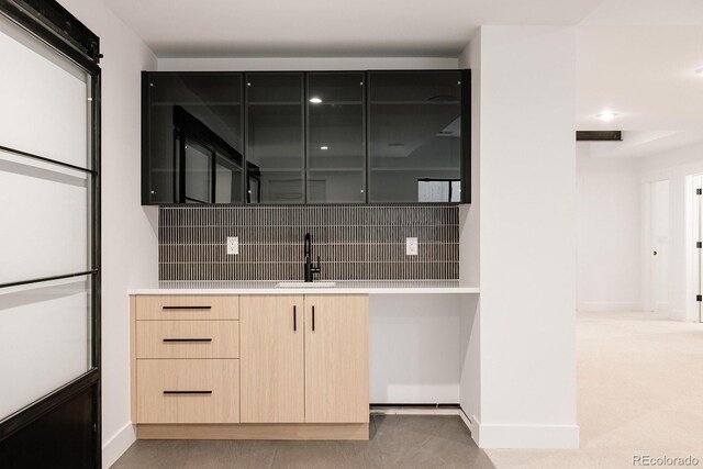 kitchen with tasteful backsplash, sink, and light brown cabinets