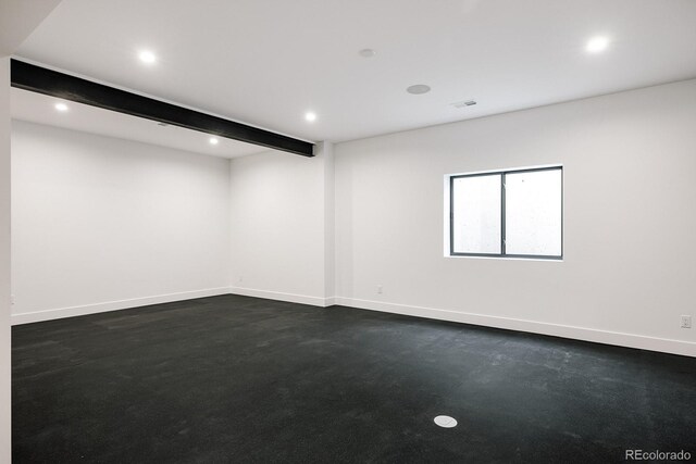 empty room featuring beam ceiling