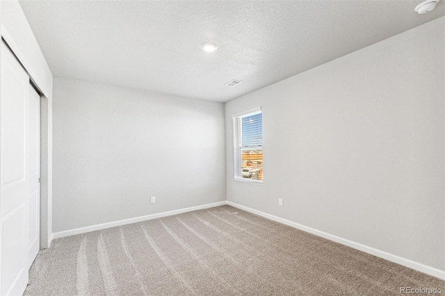 unfurnished bedroom with a closet, carpet, and a textured ceiling