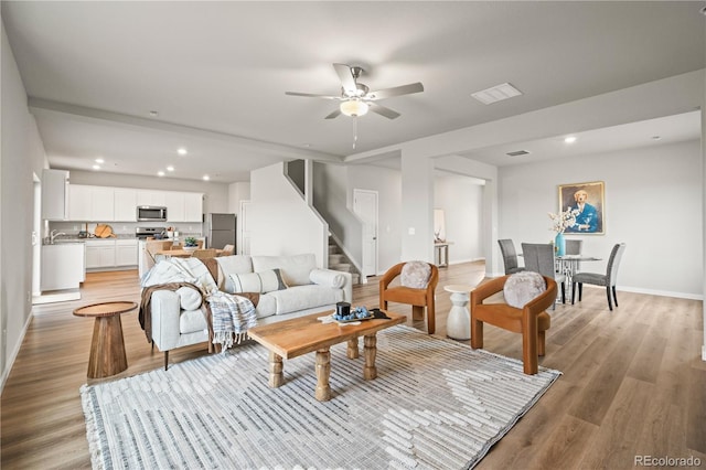 living room featuring ceiling fan and light wood-type flooring