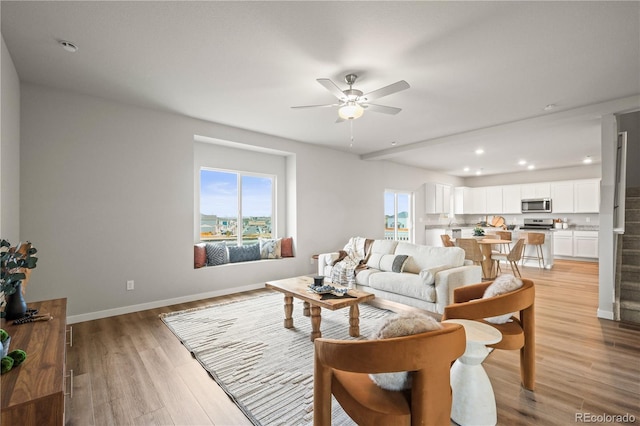 living room featuring ceiling fan and light hardwood / wood-style flooring