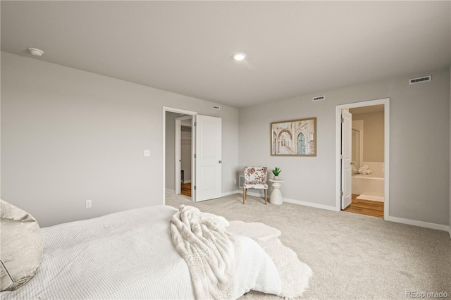 bedroom with light carpet and ensuite bathroom