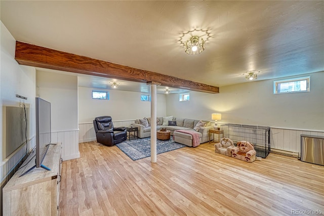 living room featuring beamed ceiling and light wood-type flooring