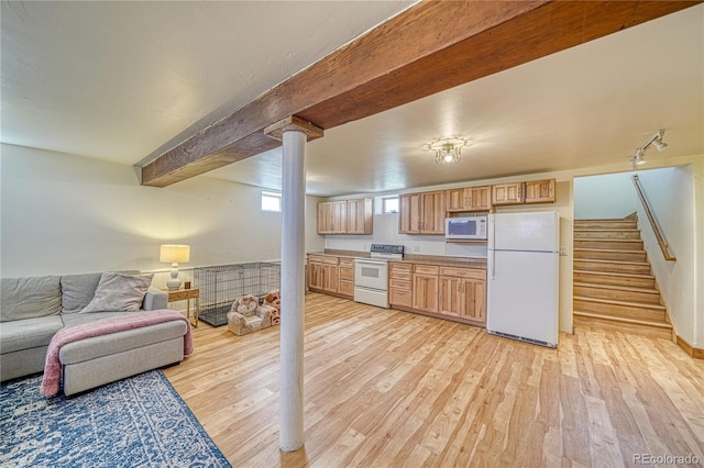 kitchen with beam ceiling, white appliances, light hardwood / wood-style floors, and light brown cabinets