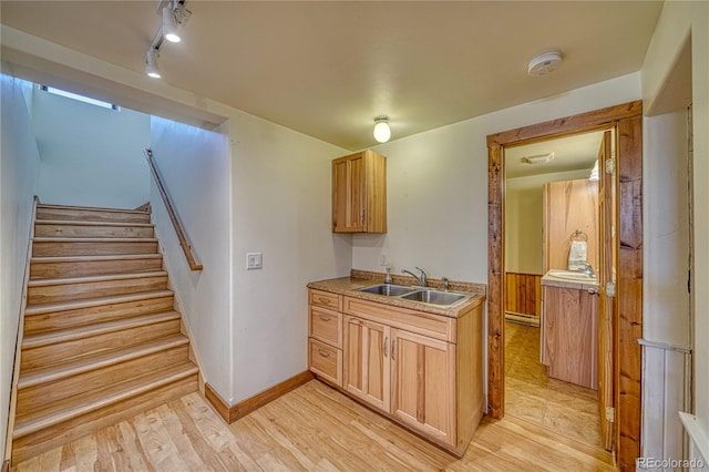 kitchen featuring track lighting, sink, a baseboard heating unit, and light tile floors