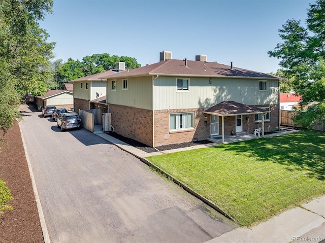 back of house with central AC and a yard